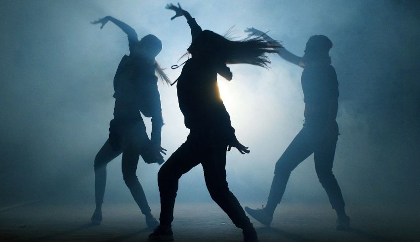 Silhouettes of people dancing in a dark room.
