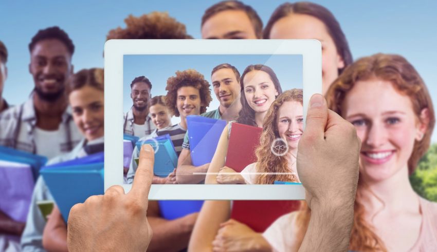 A hand holding a tablet with a group of people on it.
