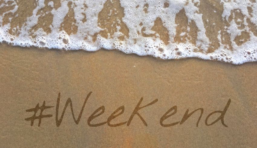 The word weekend is written on the sand.