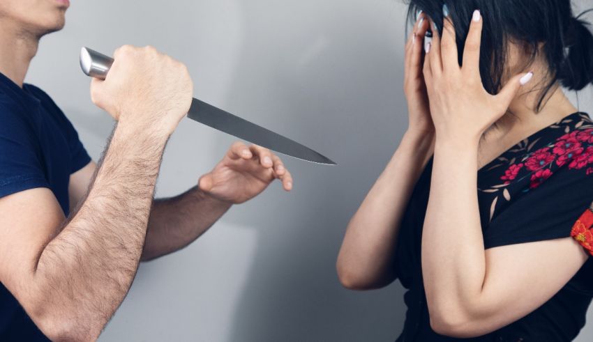 A man is holding a knife while a woman is looking at it.
