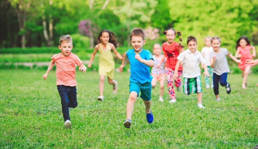 A group of children running on a grassy field.