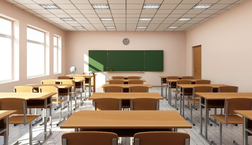 An empty classroom with wooden desks and a blackboard.