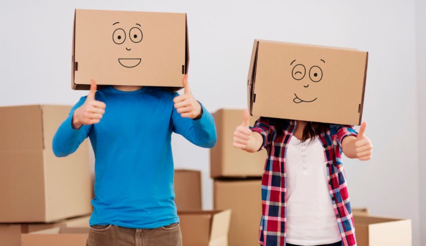 Two people with cardboard boxes on their heads giving thumbs up.