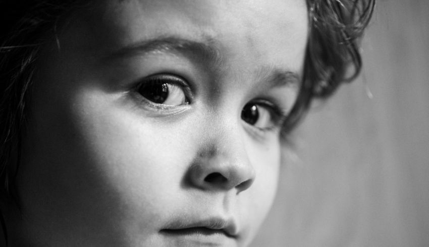 A black and white photo of a child staring at the camera.