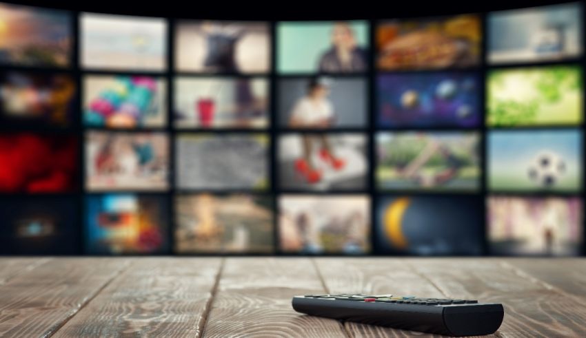 A remote control in front of a television screen.