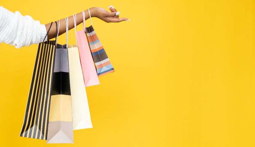 A woman holding shopping bags on a yellow background.
