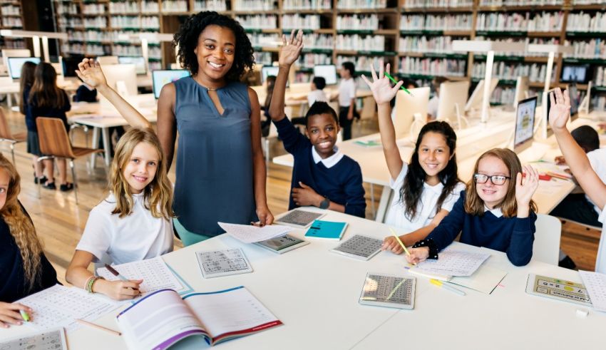 A group of school children sitting at a table in a library.