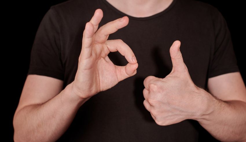 A man is making an ok sign with his hands.