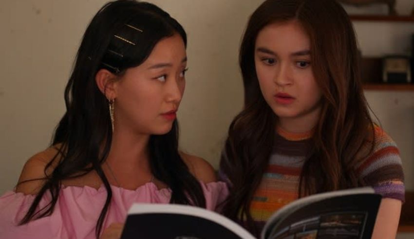 Two asian girls looking at a book.