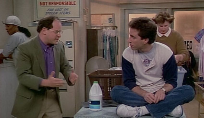 Two men in a laundry room talking to each other.