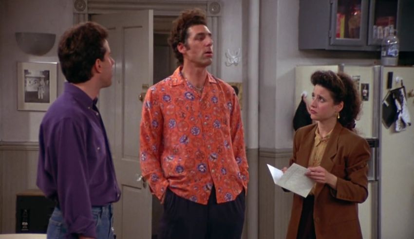 Three people standing in a kitchen talking to each other.