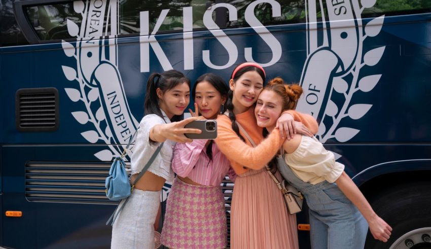 A group of girls posing in front of a bus with the word kiss on it.
