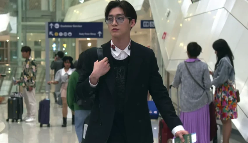 A man in a suit walking through an airport.