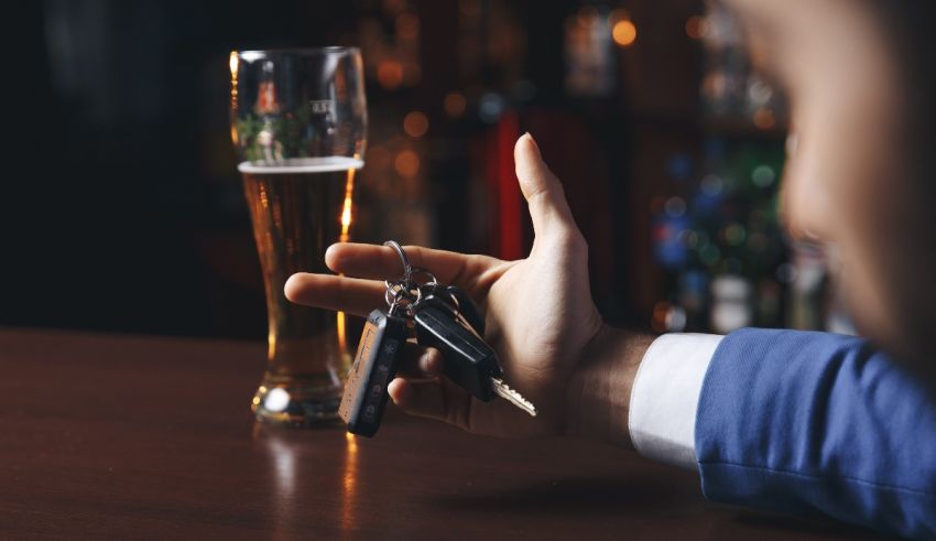 A man holding a beer glass and car keys.