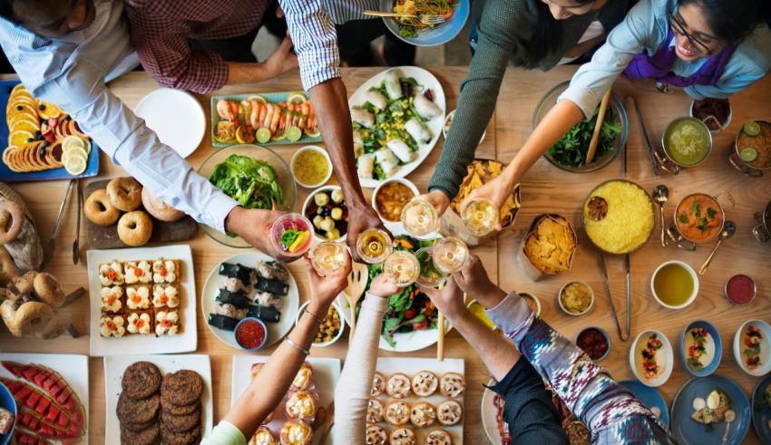 A group of people gathered around a table full of food.