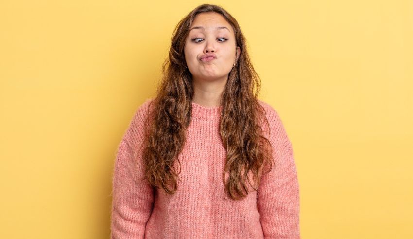 A young girl making a funny face against a yellow background.