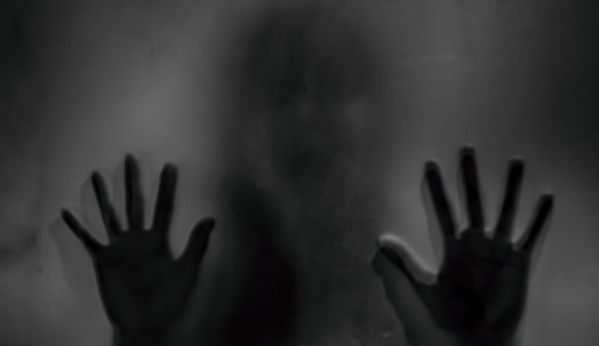 A black and white image of a person's hands in front of a dark background.