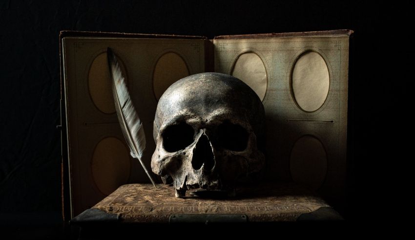 A skull sits on top of an old book.