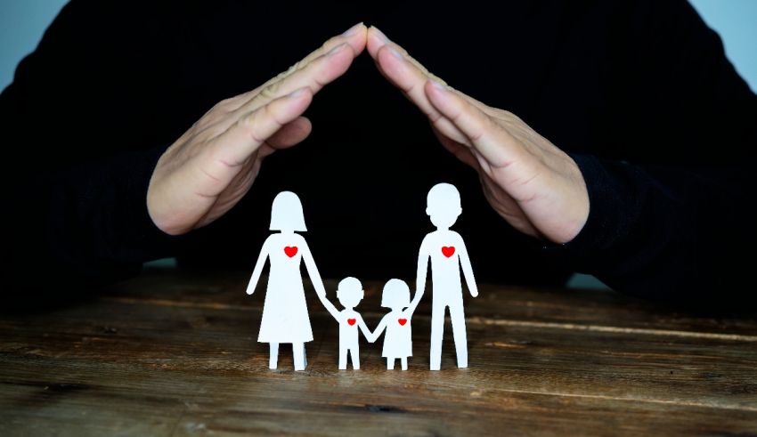 A man holding a paper cut out of a family with a heart in the middle.