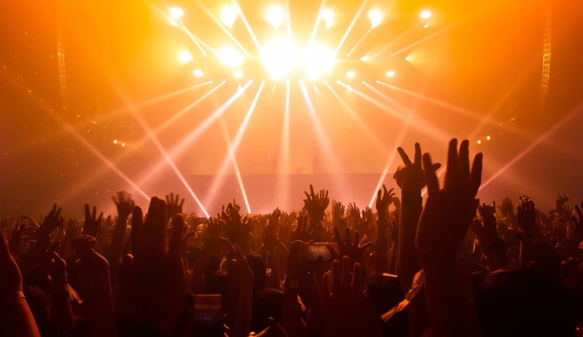 A crowd of people raising their hands at a concert.