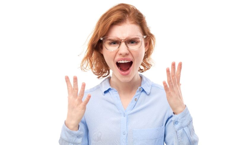 A woman yelling with her hands up on a white background.