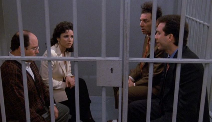 A group of people sitting in a jail cell.