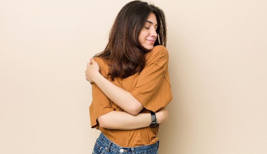 A young asian woman is hugging her chest.