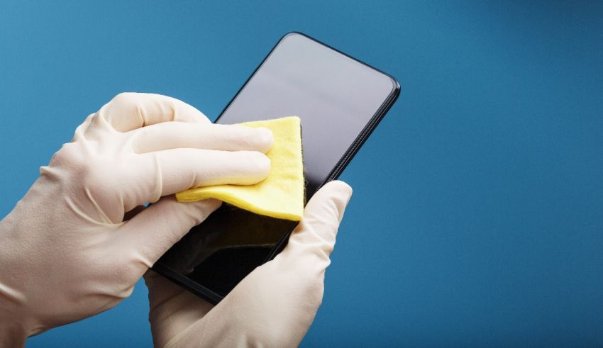 A person is cleaning a smartphone with a cloth.