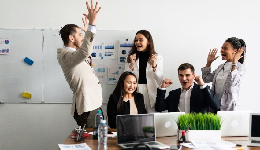 A group of business people raising their hands in an office.