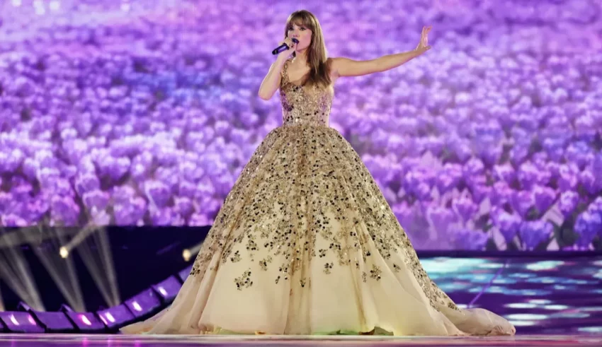 A woman in a gold gown singing into a microphone.